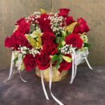 Large cascading red-rose arrangement in a gold vase with baby's breath, alstroemeria, and gold butterflies.
