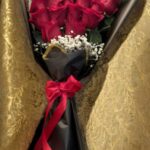 Tall luxury red-rose bouquet with baby's breath, black wrapping paper, and a red satin bow — Flower Empire.