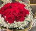 Round red-rose bouquet surrounded by a halo of baby's breath in a black-and-gold wrap — Flower Empire Toronto.