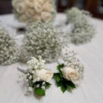 Coordinated wedding flower set: bridal bouquet, bridesmaid posies, and rose boutonnieres.