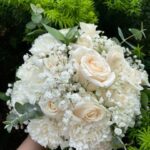 Mixed bridal bouquet of white roses, carnations, baby's breath, and eucalyptus greens.