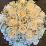 Bridal bouquet of cream-white roses, baby's breath, and pearl strands by Flower Empire Toronto.