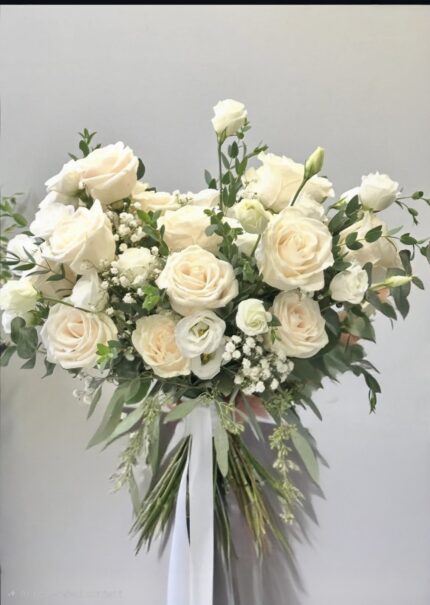 Airy white garden bridal bouquet with roses, greenery and trailing ribbon