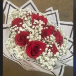 Red and ivory roses with white baby's breath in a rounded bridal bouquet