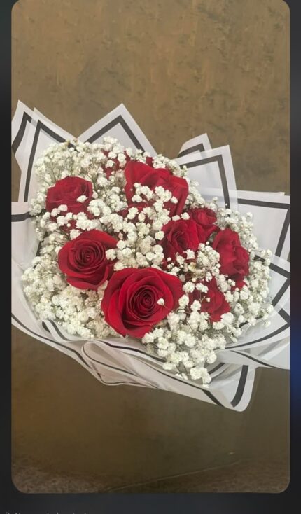 Red and ivory roses with white baby's breath in a rounded bridal bouquet