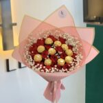 Red roses and gold-wrapped chocolates in pink wrapping