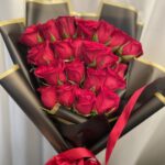 Minimal red rose bouquet in black wrapping with gold edges and red ribbon
