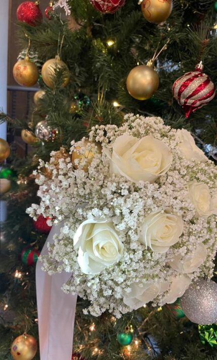 Ivory roses surrounded by baby's breath with white ribbon