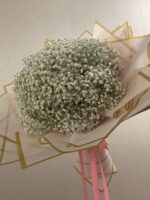 A round cloud of white baby’s breath in blush pink and gold-edged wrapping with a pink bow.