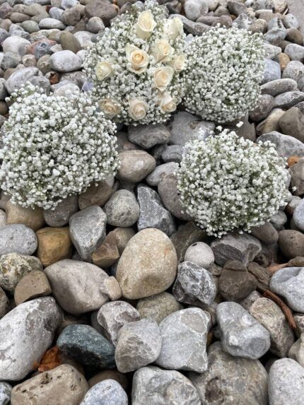 A coordinating collection of baby’s breath posies and white rose wedding flowers.