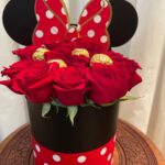 Red roses and gold-wrapped chocolates in a black-and-red polka-dot hatbox with round ears and a bow decoration.