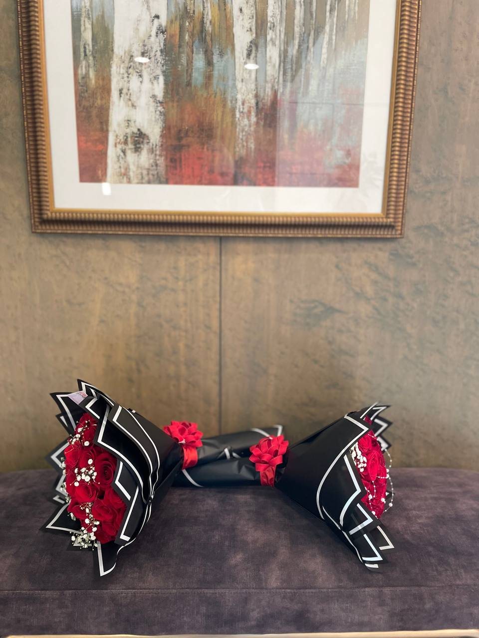 dumbbell rose gift Red roses at both ends of a decorative dumbbell-shaped presentation with black wrapping.