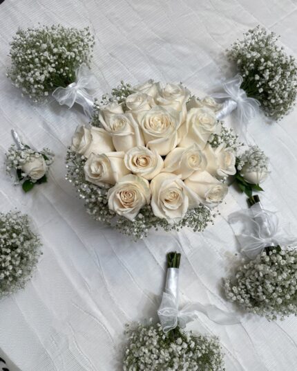 Ivory rose bridal bouquet with coordinating baby's breath bouquets and boutonnieres