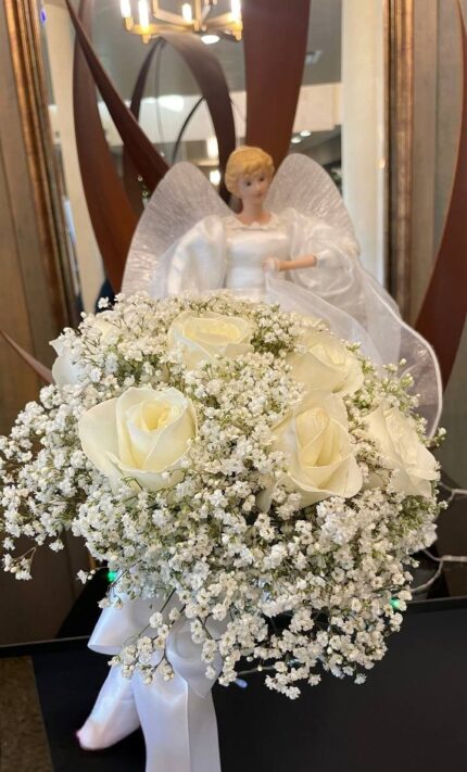 Ivory rose and baby's breath posy displayed indoors