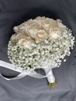 Ivory roses in a rounded bouquet with a generous white baby’s breath border and a ribbon-wrapped handle.