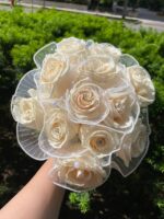 A compact ivory rose posy with a light ribbon finish for the bridal party.