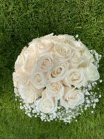A full rounded dome of ivory roses with discreet white floral accents and a wrapped handle.