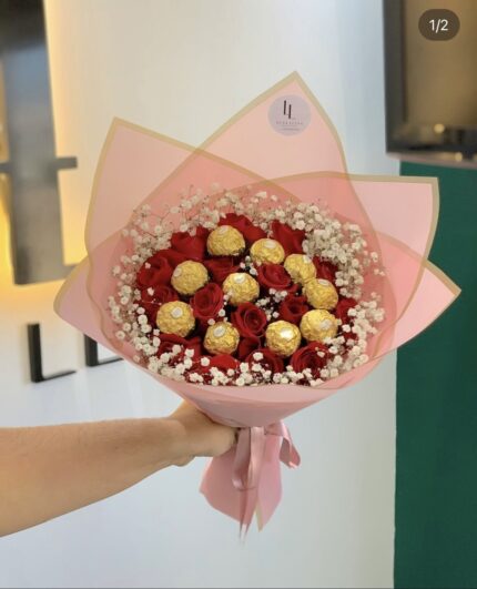 Red roses and gold-wrapped chocolates inside white baby’s breath and pink wrapping, shown in a supplied reference screenshot.