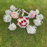 A coordinated collection of red, pink and ivory rose bouquets, baby’s breath bouquets and boutonnieres.