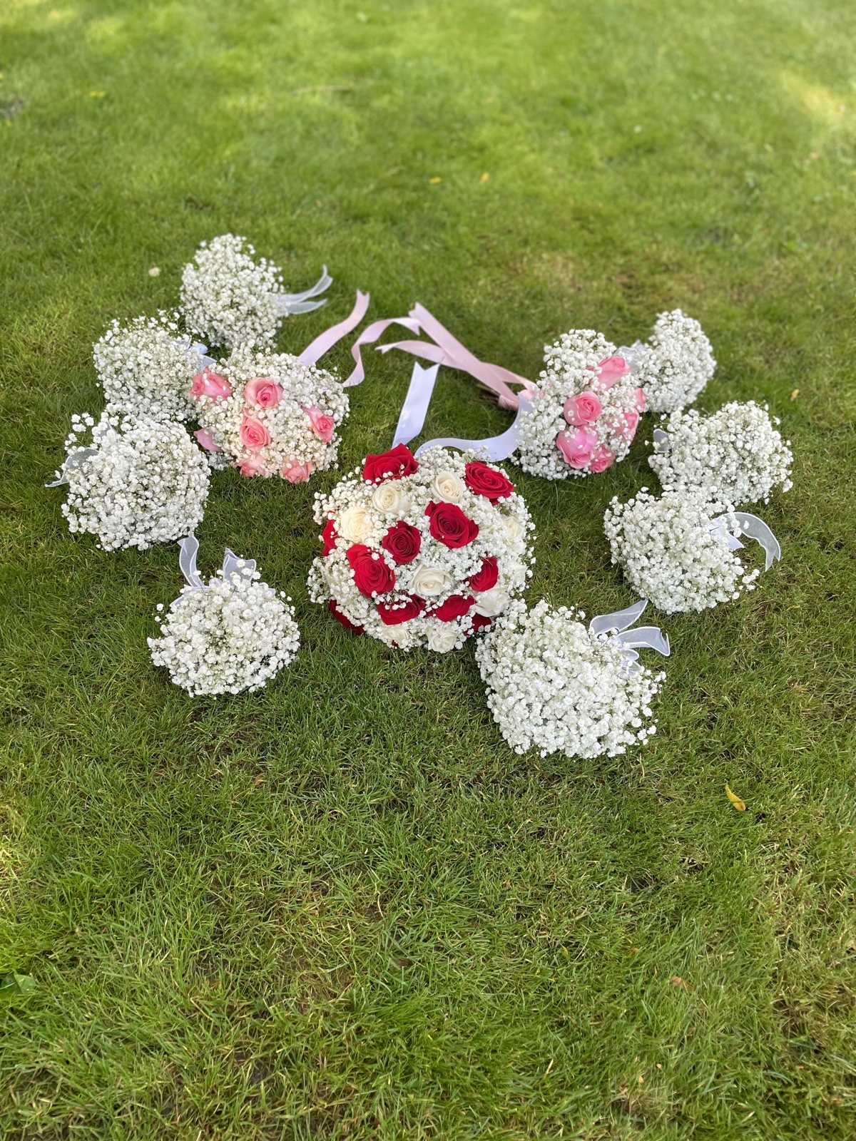 A coordinated collection of red, pink and ivory rose bouquets, baby’s breath bouquets and boutonnieres. A coordinated collection of red, pink and ivory rose bouquets, baby’s breath bouquets and boutonnieres.