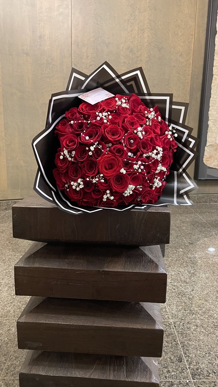 red rose pearl style accent bouquet Red roses with white bead-style accents in a dramatic black-and-white geometric wrap.