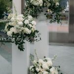 White floral clusters at different heights on pale pedestals, shown in a supplied reference screenshot.
